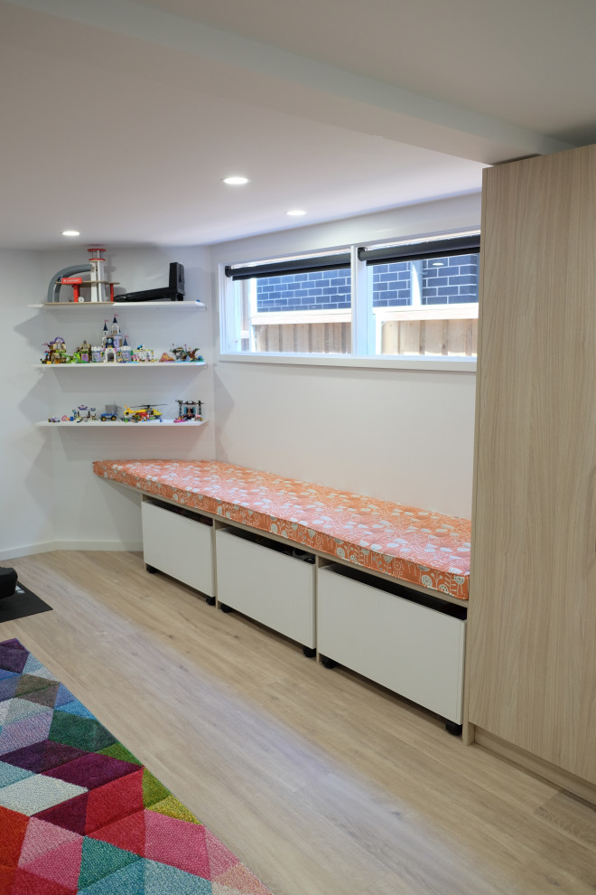 Exemple d'une grande salle de jeux d'enfant de 4 à 10 ans tendance avec un mur blanc et un sol en vinyl.