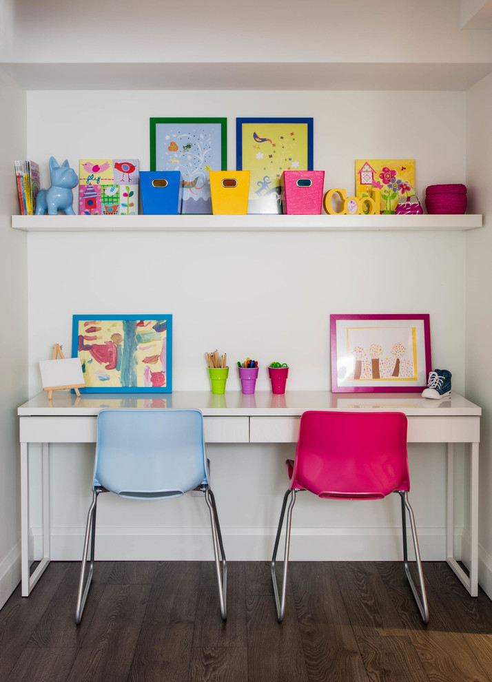 Cette photo montre une chambre d'enfant chic avec un bureau, un mur blanc et parquet foncé.