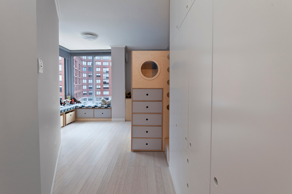 Inspiration for a large contemporary children’s room for boys in New York with grey walls and light hardwood flooring.