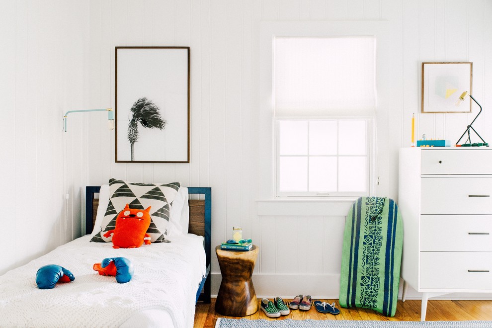 Inspiration for a beach style gender neutral kids' bedroom in Charleston with white walls, medium hardwood flooring and brown floors.