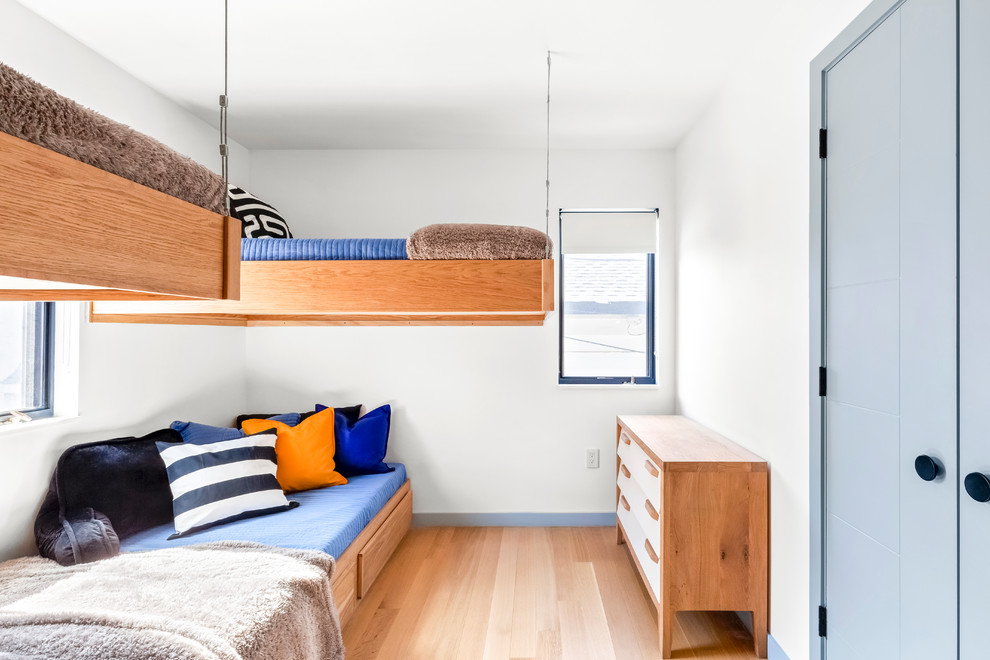 Mittelgroßes Modernes Kinderzimmer mit Schlafplatz, weißer Wandfarbe, braunem Holzboden und braunem Boden in New York