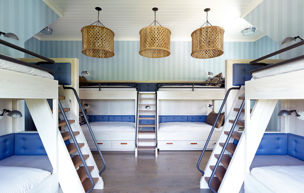 Idéer för ett maritimt könsneutralt barnrum kombinerat med sovrum, med blå väggar och mörkt trägolv