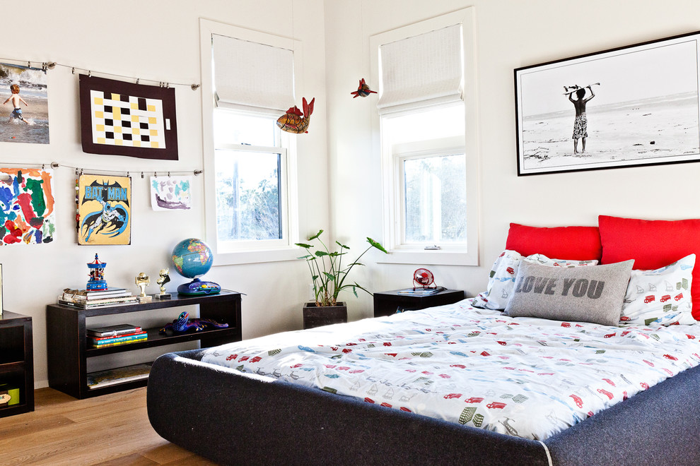 Photo of a coastal teen’s room for boys in Charleston with white walls and light hardwood flooring.