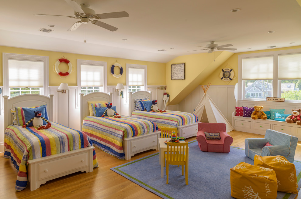 Idéer för att renovera ett maritimt könsneutralt barnrum kombinerat med sovrum, med gula väggar, mellanmörkt trägolv och brunt golv
