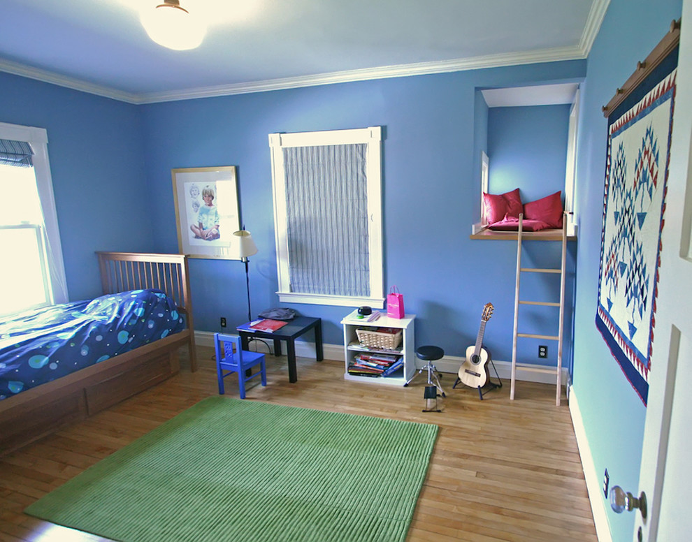 Immagine di una cameretta per bambini da 4 a 10 anni tradizionale di medie dimensioni con pareti blu e parquet chiaro