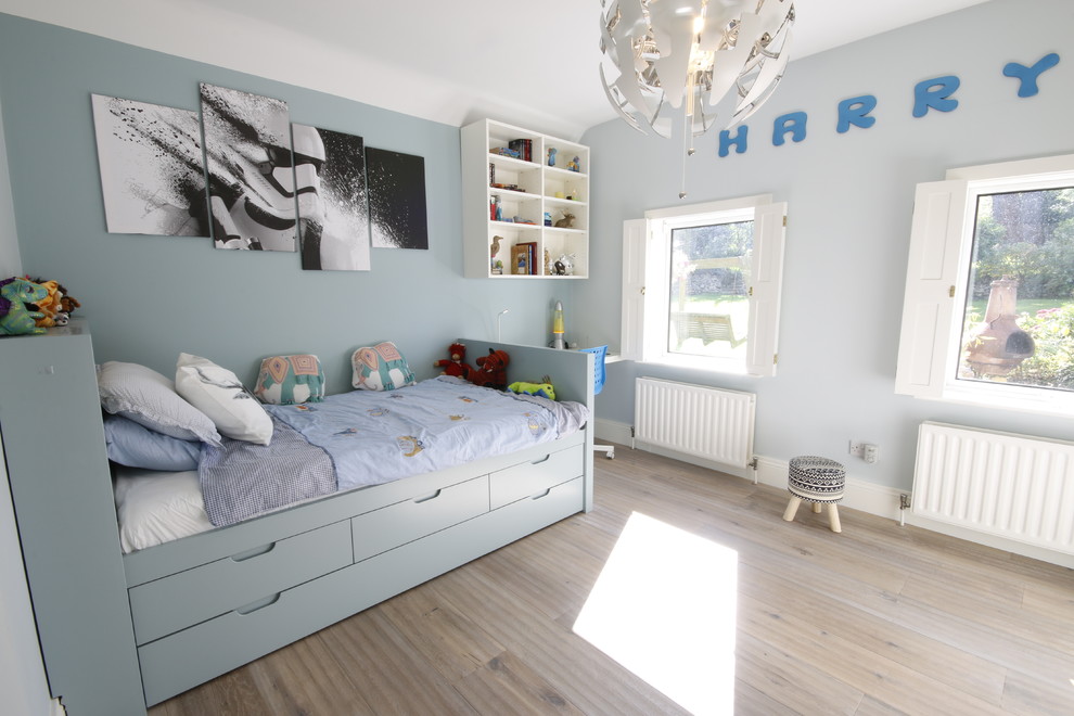 Inredning av ett modernt mellanstort pojkrum kombinerat med sovrum och för 4-10-åringar, med grå väggar och ljust trägolv