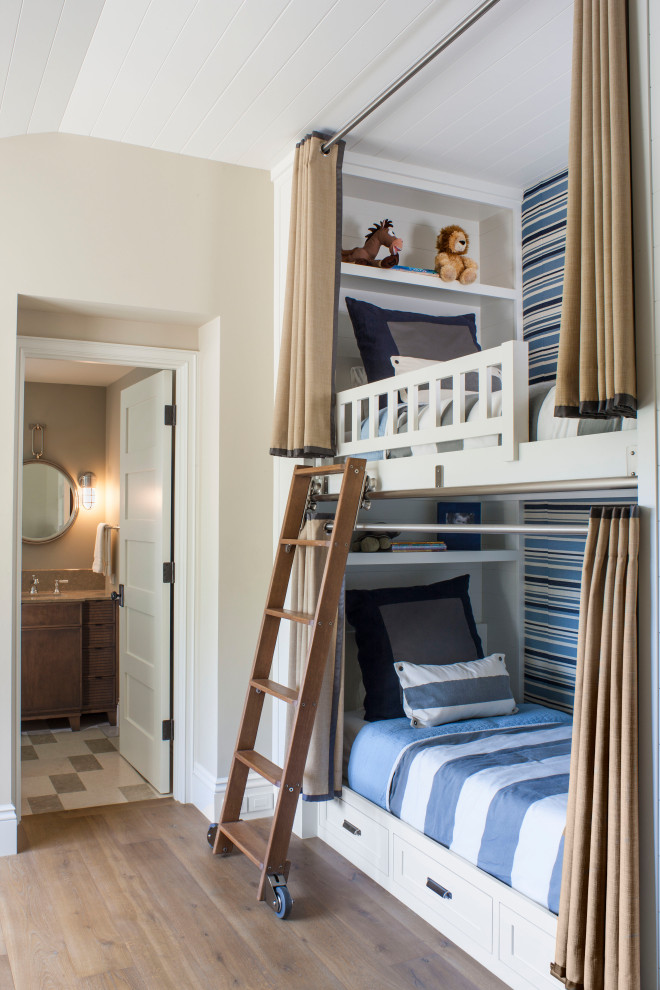 Modelo de dormitorio infantil de 4 a 10 años clásico renovado de tamaño medio con paredes beige, suelo de madera en tonos medios, suelo marrón y papel pintado