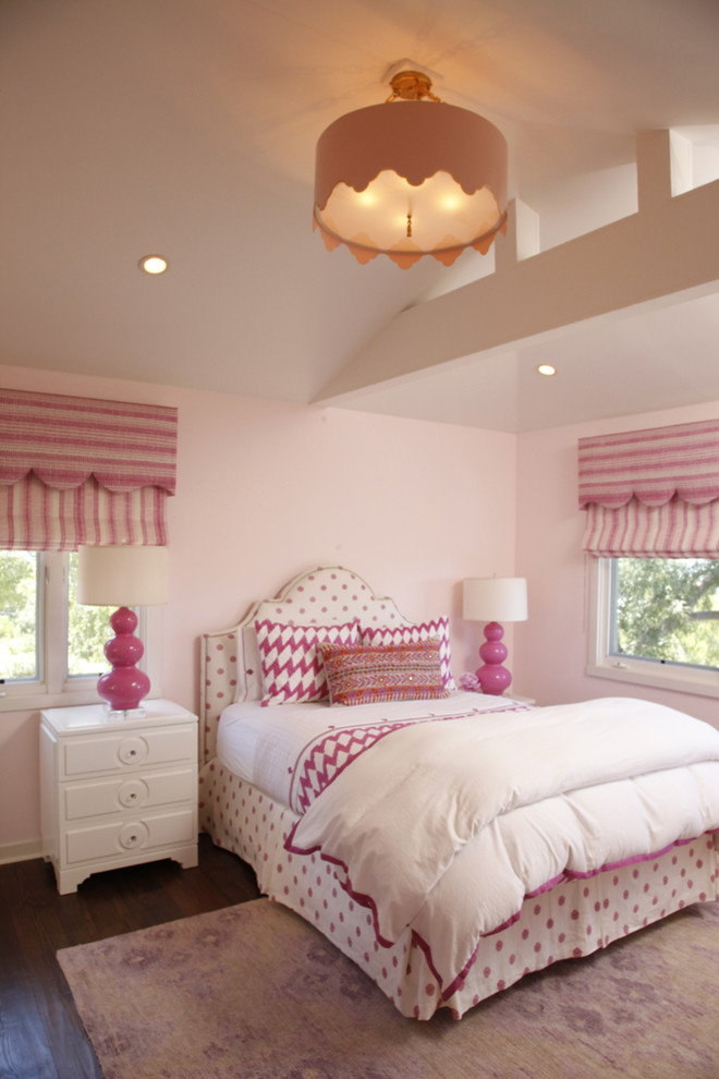 This is an example of a medium sized traditional children’s room for girls in Los Angeles with pink walls and dark hardwood flooring.