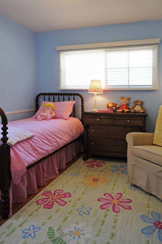 Bild på ett mellanstort eklektiskt barnrum kombinerat med sovrum, med blå väggar och ljust trägolv