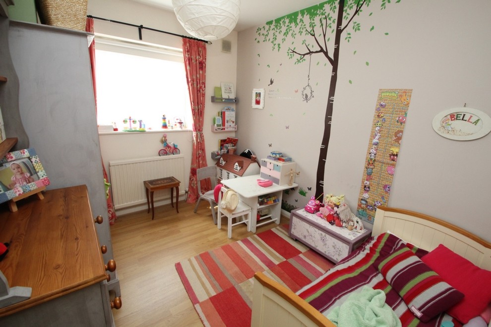 Modelo de dormitorio infantil de 1 a 3 años romántico pequeño con paredes beige y suelo de madera clara
