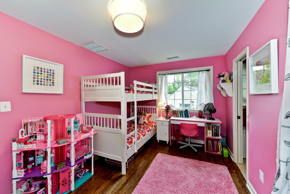 Cette photo montre une chambre d'enfant chic avec un mur rose et parquet foncé.