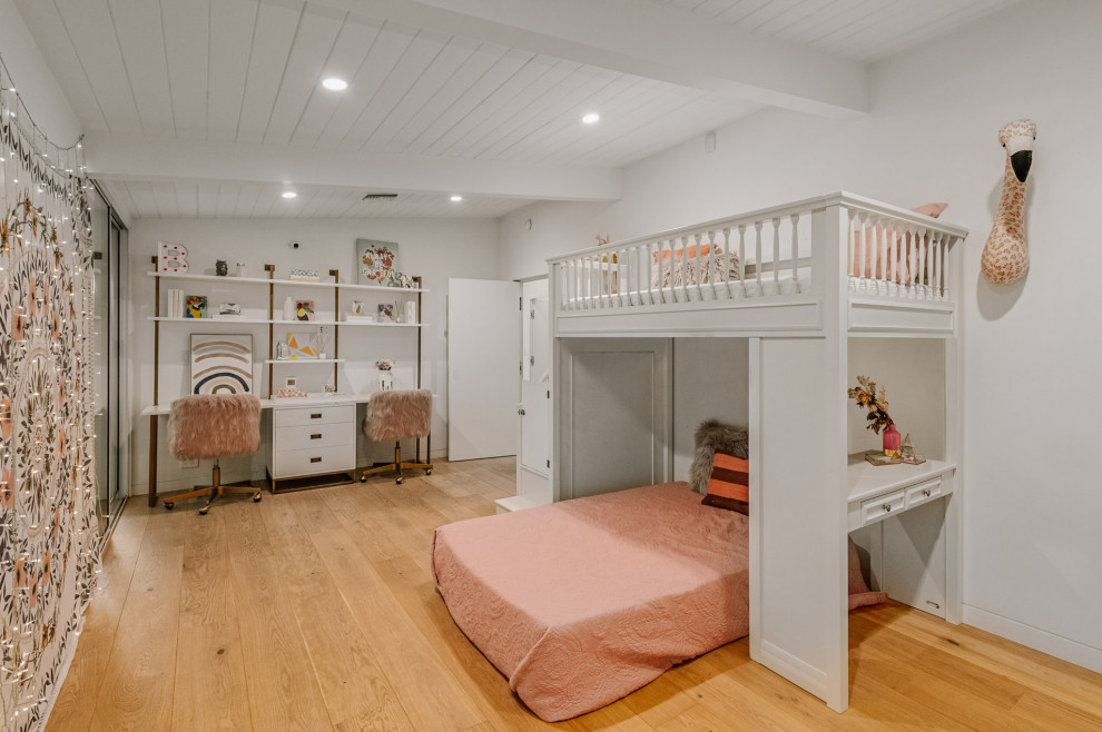 Photo of a large midcentury children’s room for girls in Los Angeles with white walls, light hardwood flooring and beige floors.