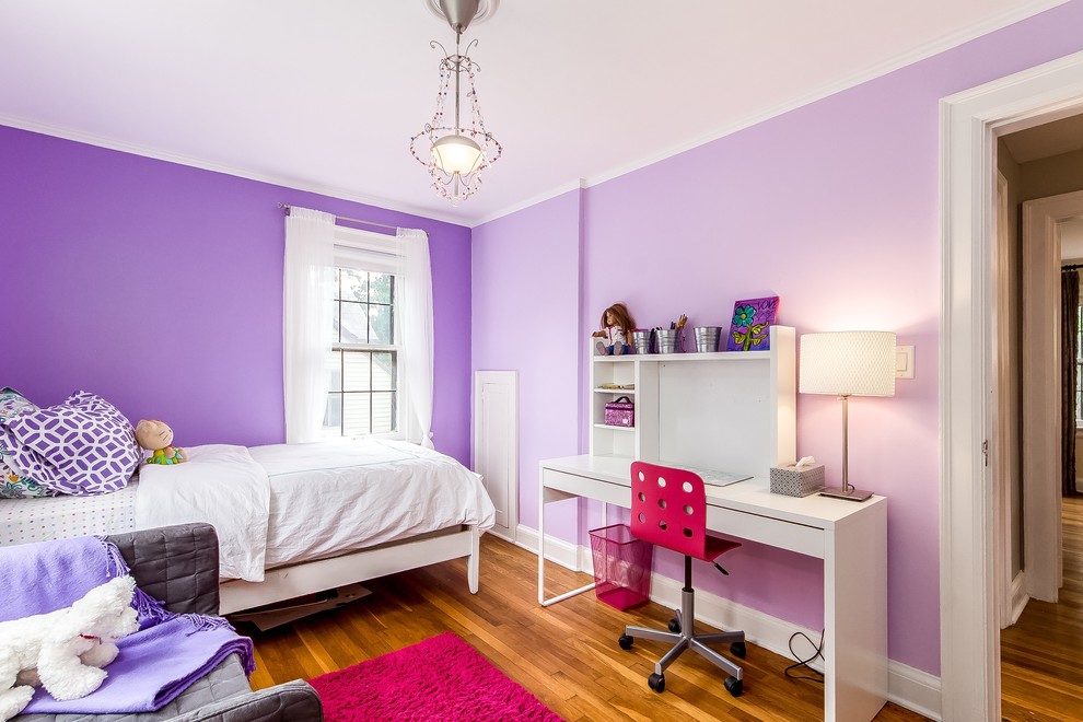 Ejemplo de dormitorio infantil clásico renovado con paredes púrpuras y suelo de madera en tonos medios