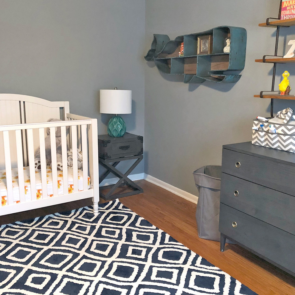 Foto de habitación de bebé niño urbana de tamaño medio con paredes azules y suelo de madera en tonos medios