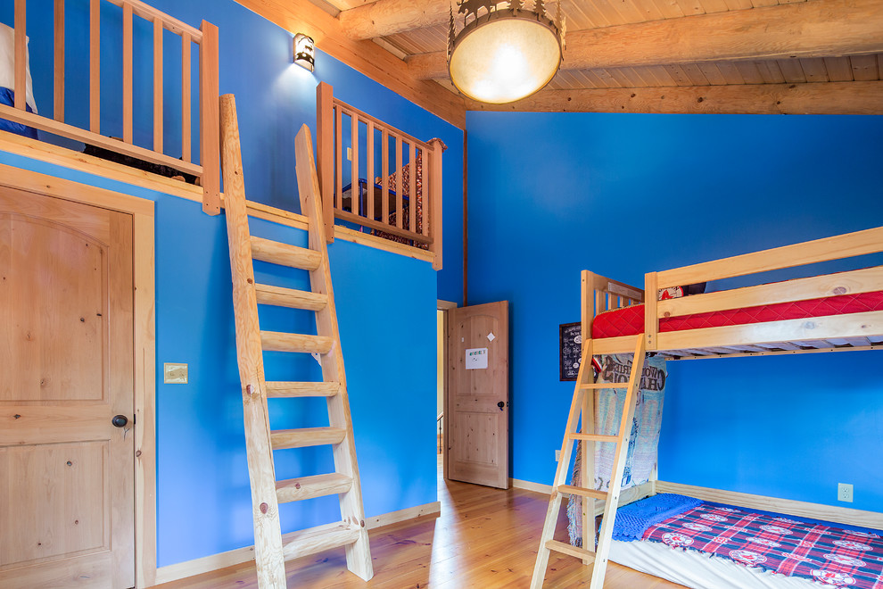Réalisation d'une chambre d'enfant chalet avec un mur bleu et un sol en bois brun.