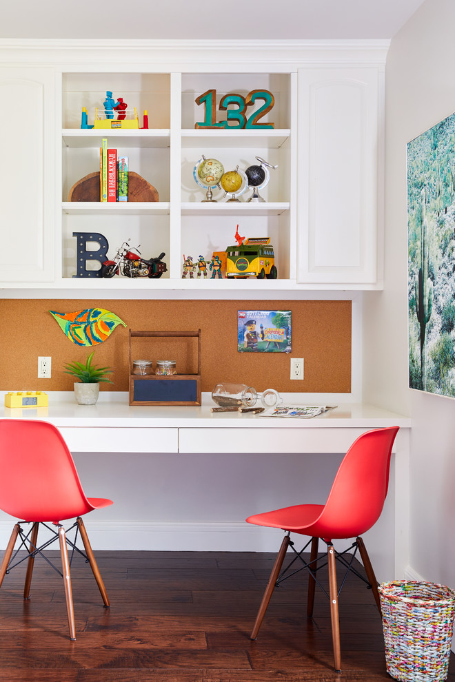 Cette image montre une petite chambre de garçon de 4 à 10 ans traditionnelle avec un bureau, un mur blanc et parquet foncé.