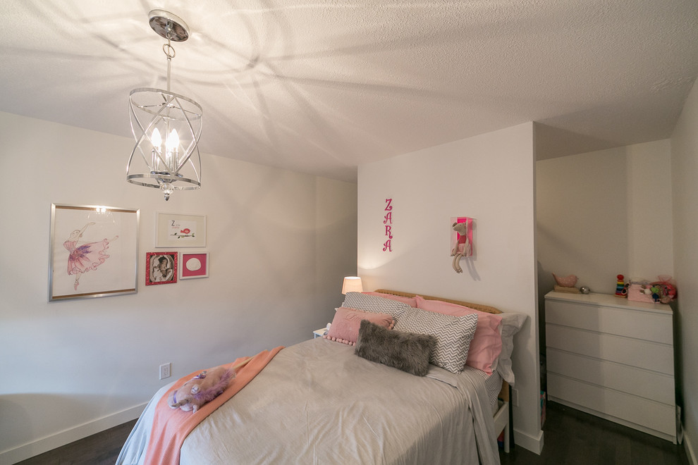 Inredning av ett modernt mellanstort flickrum kombinerat med sovrum och för 4-10-åringar, med vita väggar och mörkt trägolv