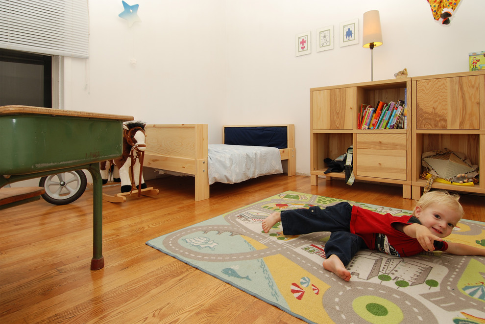 Diseño de dormitorio infantil de 1 a 3 años contemporáneo con paredes blancas y suelo de madera en tonos medios