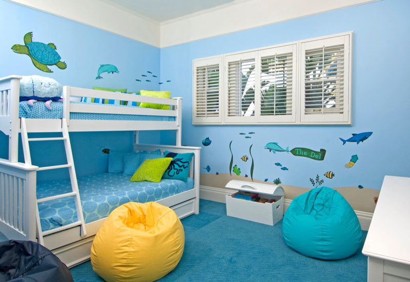 Inredning av ett maritimt stort könsneutralt småbarnsrum kombinerat med sovrum, med blå väggar och heltäckningsmatta