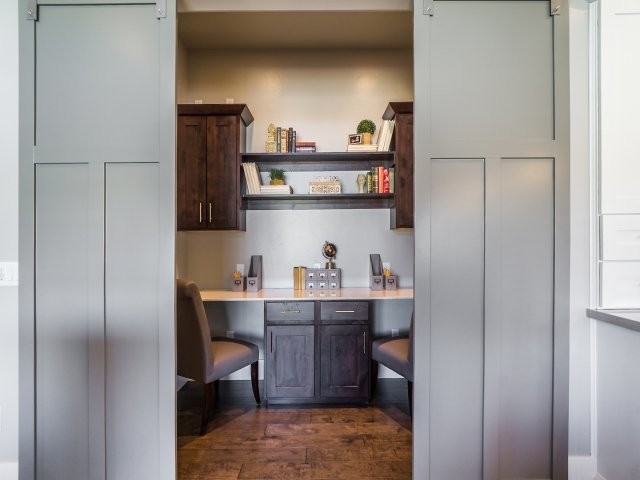 Imagen de habitación infantil unisex tradicional renovada pequeña con escritorio, paredes grises y suelo de madera en tonos medios