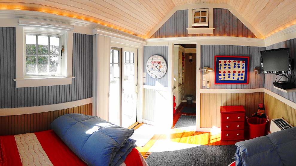 Inredning av ett maritimt litet könsneutralt barnrum kombinerat med sovrum, med mellanmörkt trägolv och flerfärgade väggar