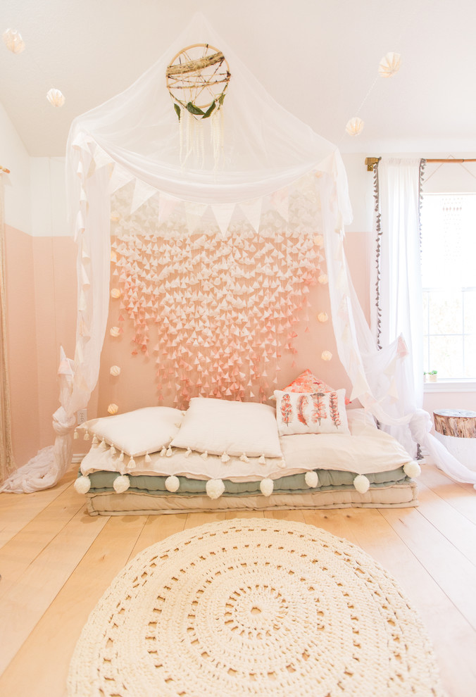 Idées déco pour une chambre de fille scandinave avec un mur rose et parquet clair.