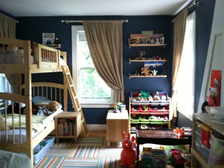 This is an example of a medium sized eclectic gender neutral children’s room in Boston with blue walls and light hardwood flooring.