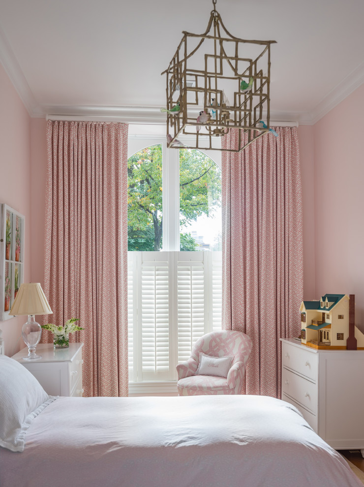 This is an example of a traditional kids' bedroom for girls in Boston with pink walls.