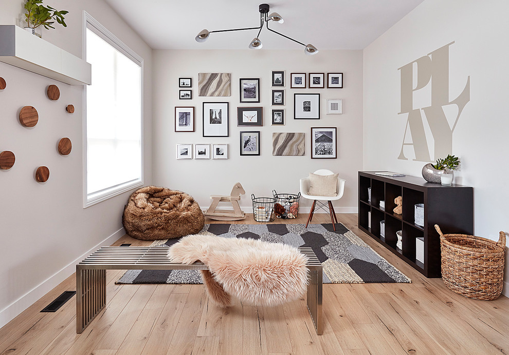 Trendy gender-neutral light wood floor and beige floor playroom photo in Edmonton with white walls