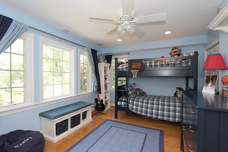 Ejemplo de dormitorio infantil tradicional renovado de tamaño medio con paredes azules, suelo de madera en tonos medios y suelo marrón