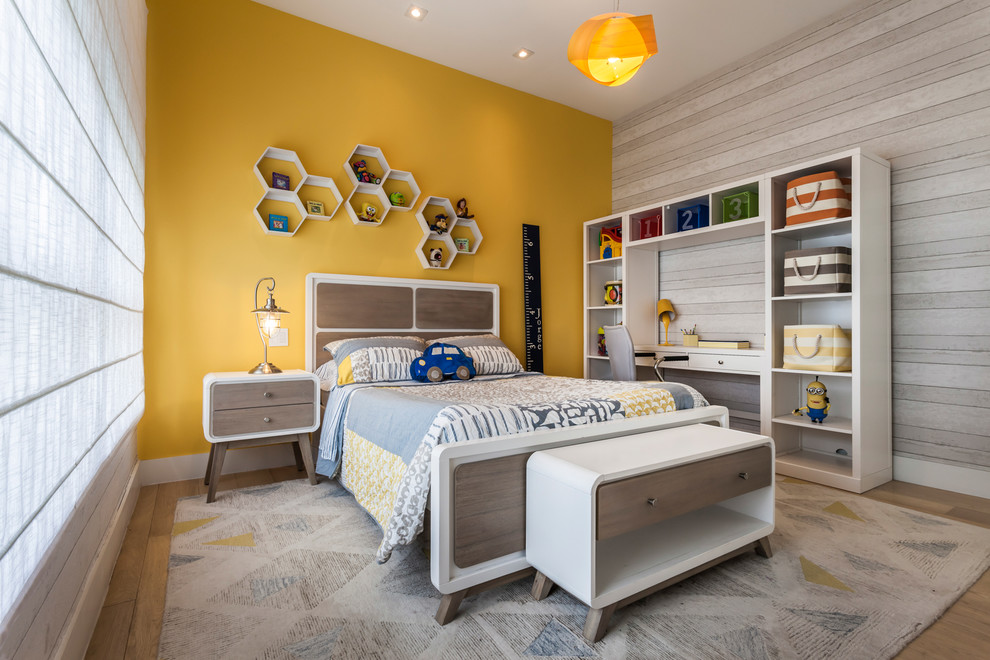 Imagen de dormitorio infantil de 4 a 10 años actual de tamaño medio con suelo de contrachapado y paredes amarillas