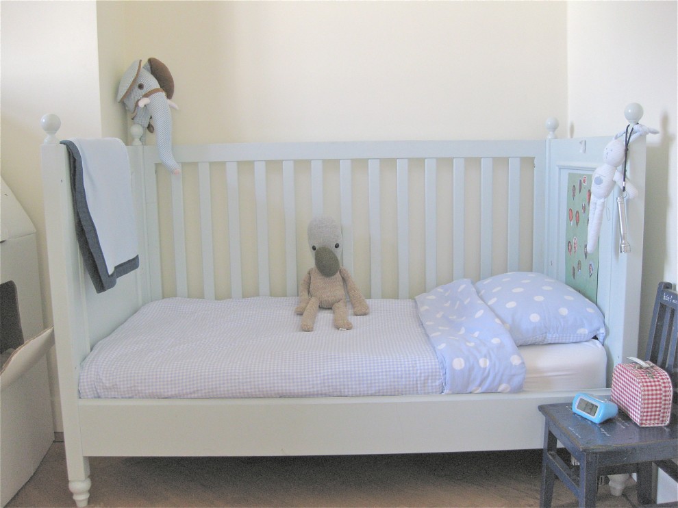 Foto på ett eklektiskt könsneutralt småbarnsrum kombinerat med sovrum, med vita väggar och heltäckningsmatta