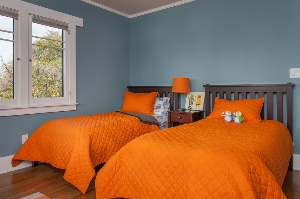 Foto på ett mellanstort amerikanskt pojkrum kombinerat med sovrum och för 4-10-åringar, med blå väggar och mellanmörkt trägolv