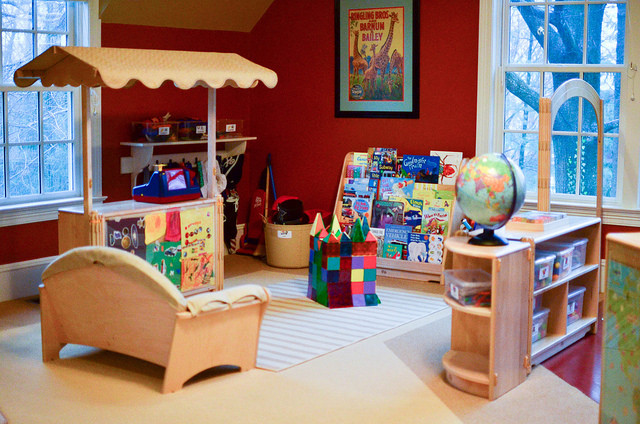 This is an example of a medium sized classic gender neutral kids' bedroom in New York with red walls and carpet.