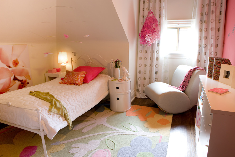 Cette photo montre une petite chambre d'enfant tendance avec un mur blanc et un sol en bois brun.