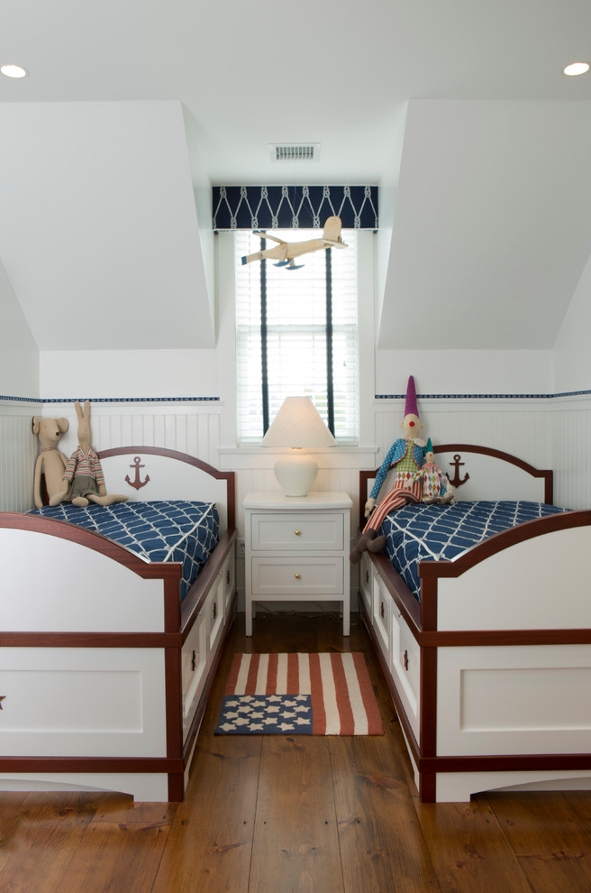 Medium sized nautical children’s room for boys in Boston with white walls, dark hardwood flooring and brown floors.