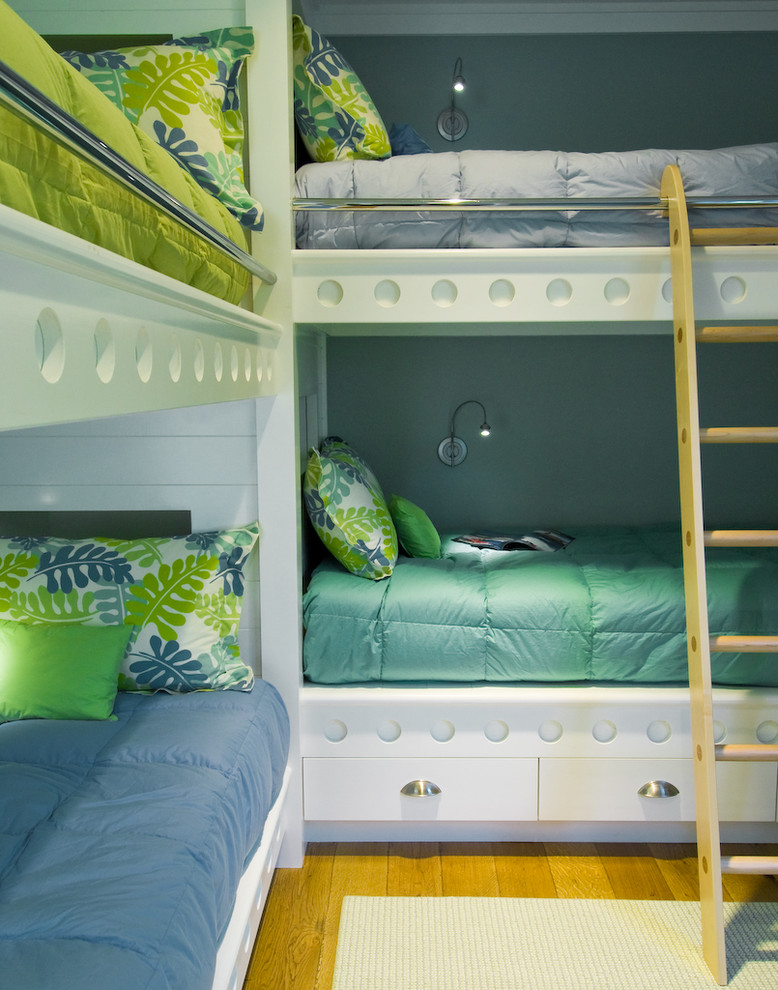 На фото: нейтральная детская в морском стиле с спальным местом, синими стенами и паркетным полом среднего тона для ребенка от 4 до 10 лет, двоих детей с