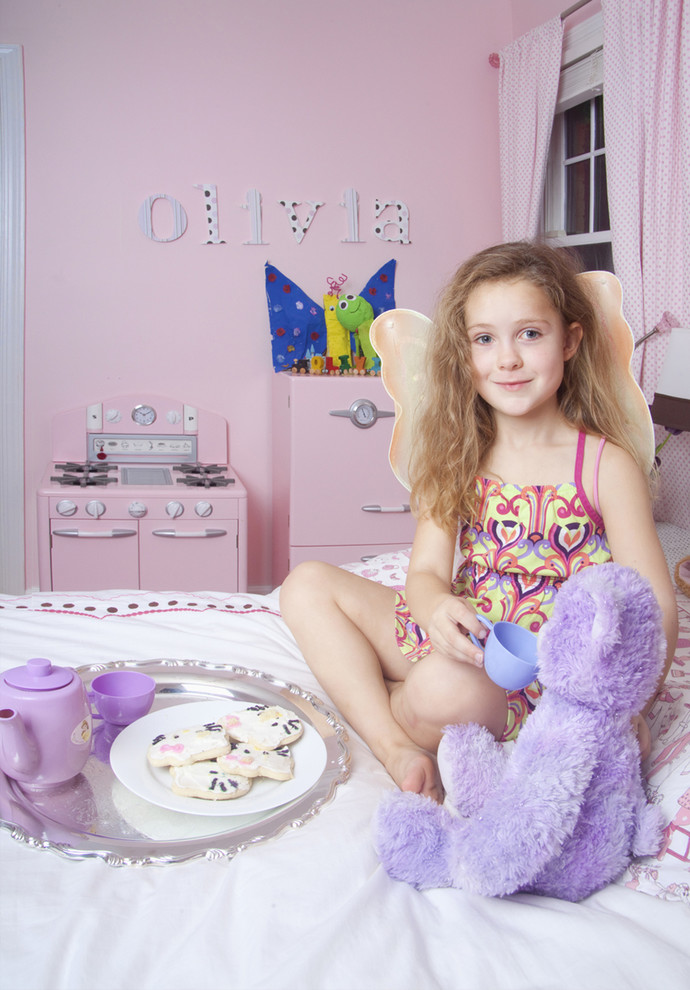 Immagine di una cameretta da bambina eclettica con pareti rosa