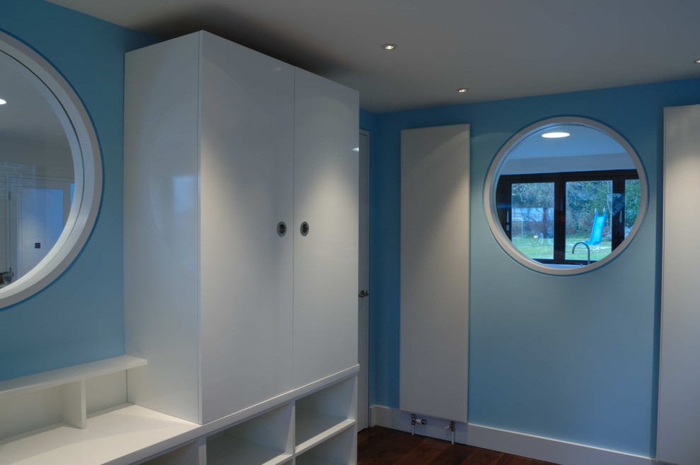 Cette photo montre une chambre d'enfant de 4 à 10 ans moderne de taille moyenne avec un mur bleu et parquet foncé.