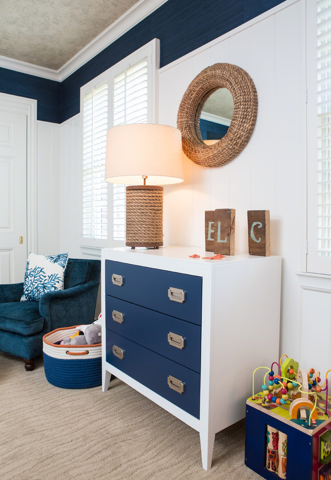 Medium sized traditional toddler’s room for boys in Los Angeles with blue walls and carpet.