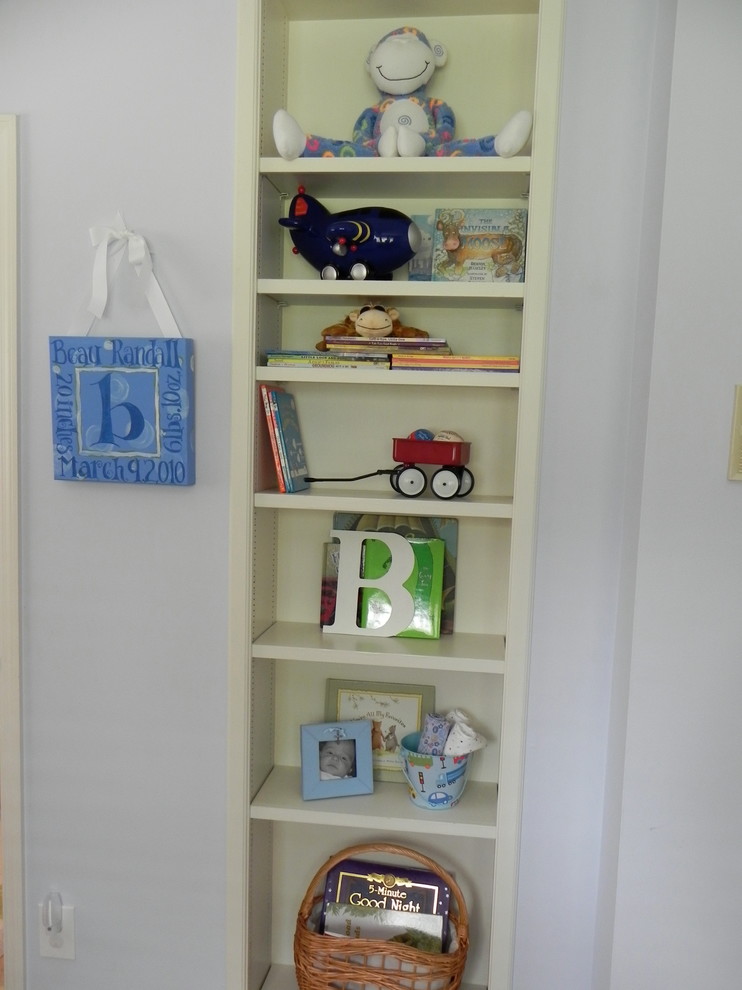 Cette photo montre une chambre d'enfant de 1 à 3 ans craftsman de taille moyenne avec un mur bleu et un sol en bois brun.