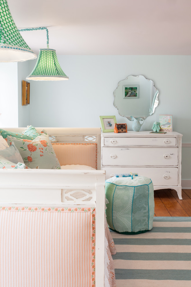 Modelo de dormitorio infantil romántico de tamaño medio con paredes azules, suelo de madera clara y suelo azul