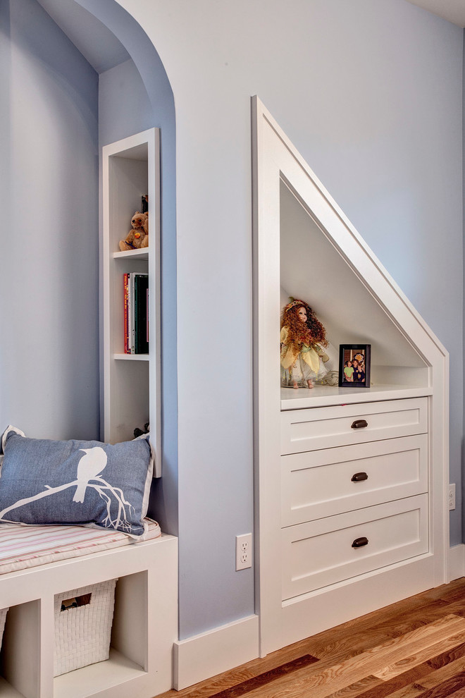 This is an example of a medium sized classic children’s room for girls in Seattle with blue walls and medium hardwood flooring.