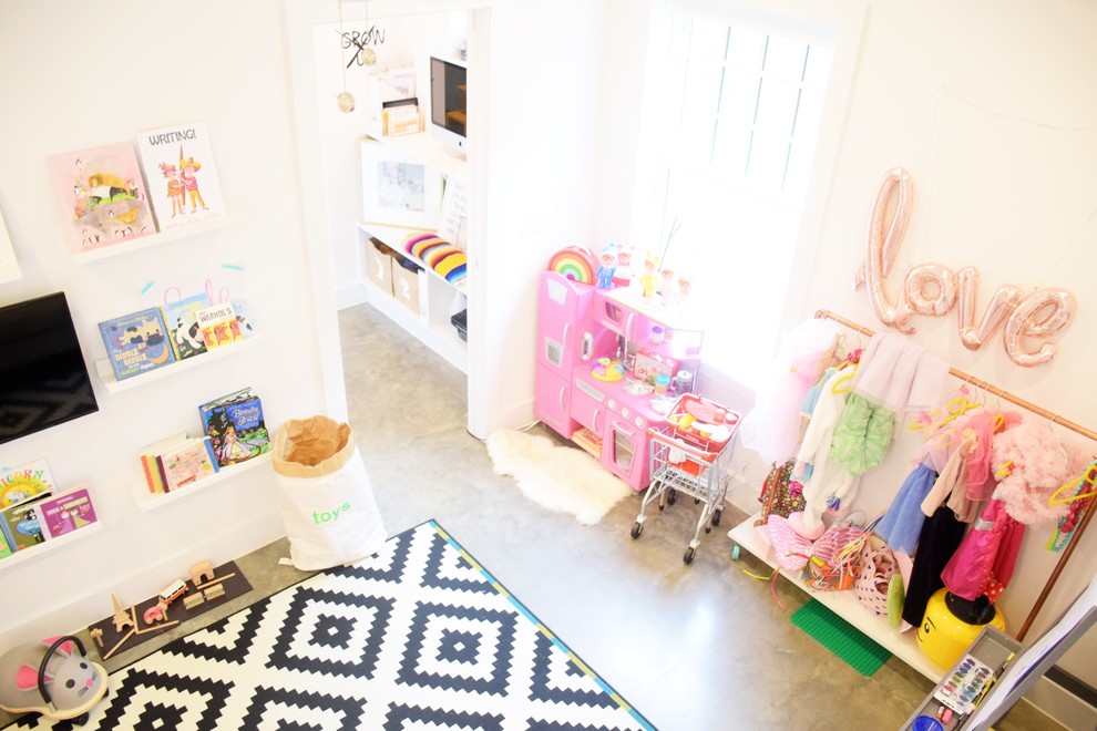 Cette photo montre une petite chambre d'enfant de 4 à 10 ans éclectique avec un mur blanc, sol en béton ciré et un sol gris.