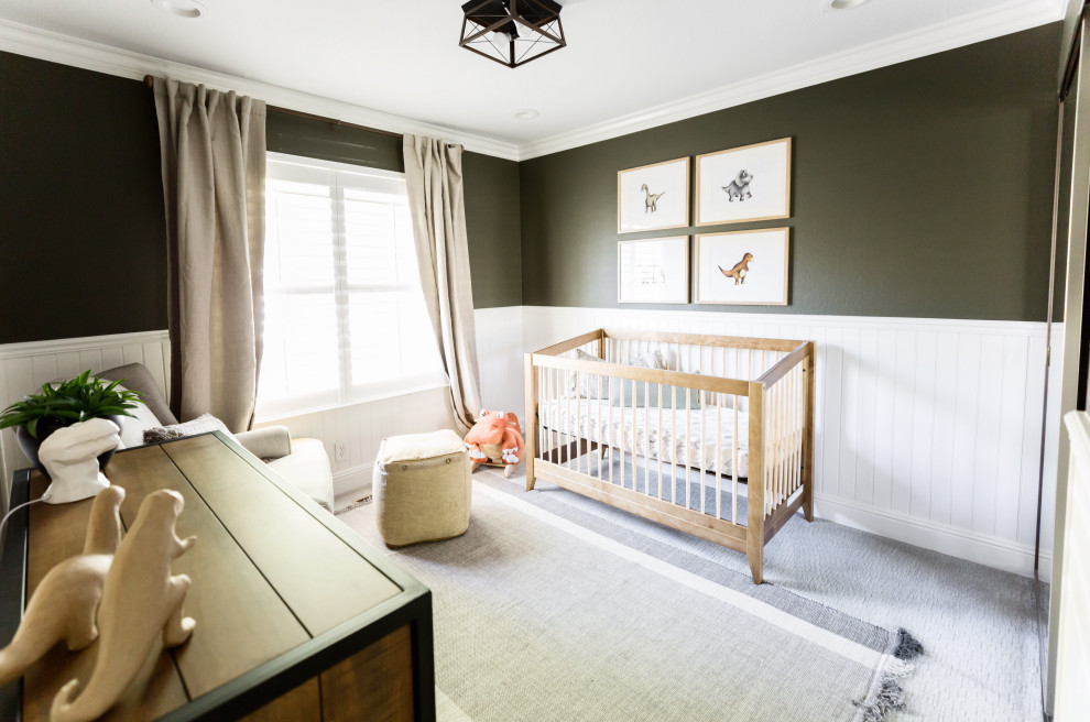 Immagine di una piccola cameretta per neonato chic con pareti verdi e moquette