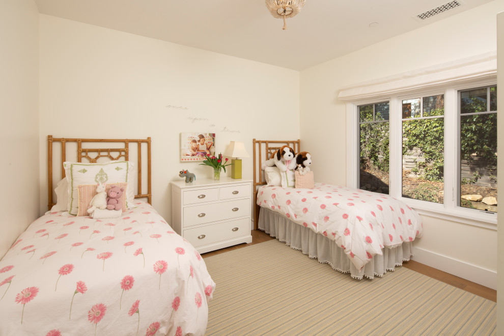 Modelo de dormitorio infantil costero con paredes blancas, suelo de madera en tonos medios y suelo marrón