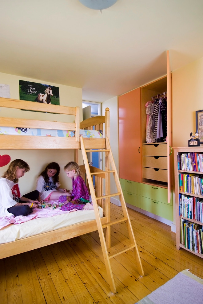 Ispirazione per una cameretta per bambini da 4 a 10 anni bohémian con pareti beige e pavimento in legno massello medio