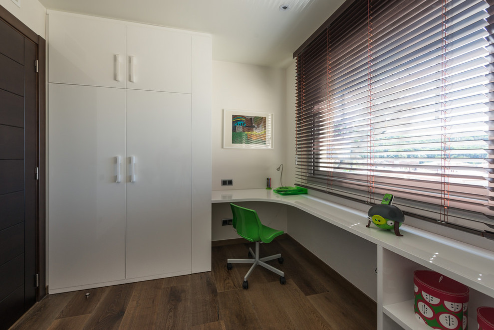 Imagen de habitación infantil unisex de 4 a 10 años contemporánea de tamaño medio con escritorio, paredes blancas y suelo de madera en tonos medios