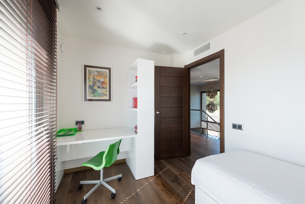 Modelo de dormitorio infantil de 4 a 10 años actual de tamaño medio con paredes blancas y suelo de madera oscura