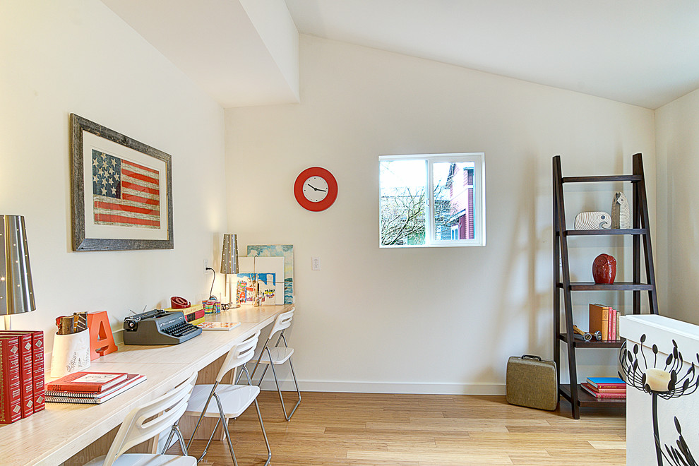 Cette photo montre une chambre d'enfant chic avec un bureau, un mur blanc et parquet clair.